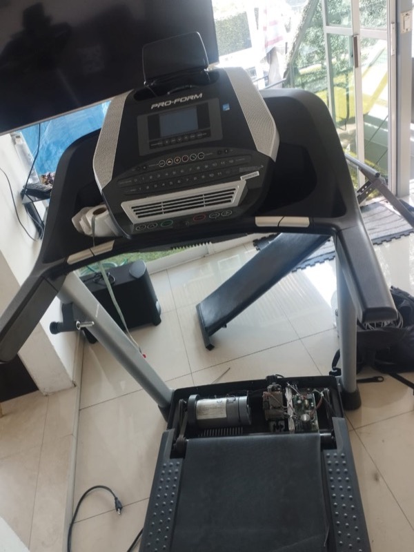 Técnico reparando caminadora eléctrica