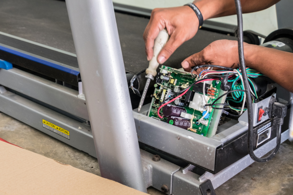 Técnico reparando caminadora eléctrica a domicilio